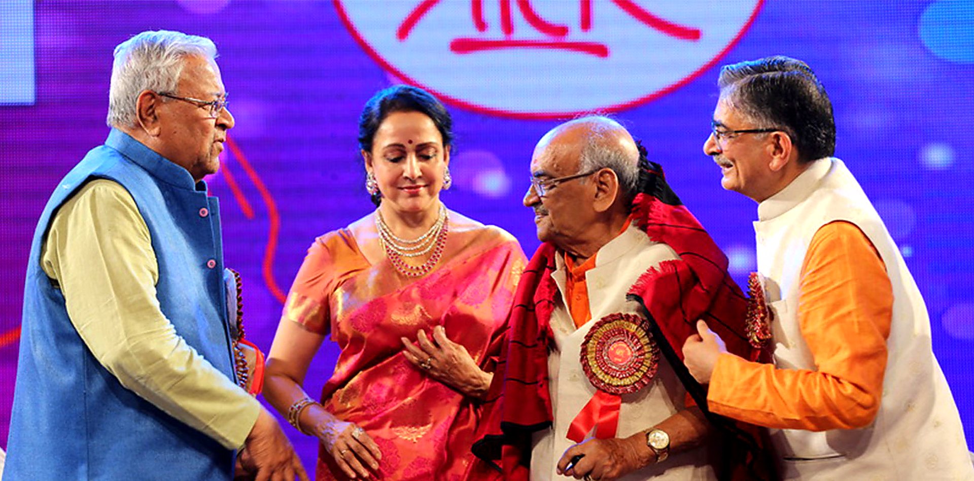 Office bearers greet a guest on stage at the annual function